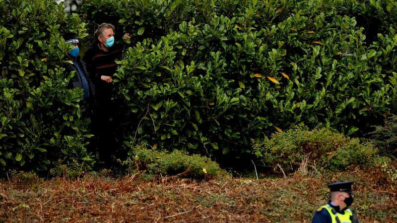Local spectators look on from between the bushes. Photo: Ryan Byrne/Inpho