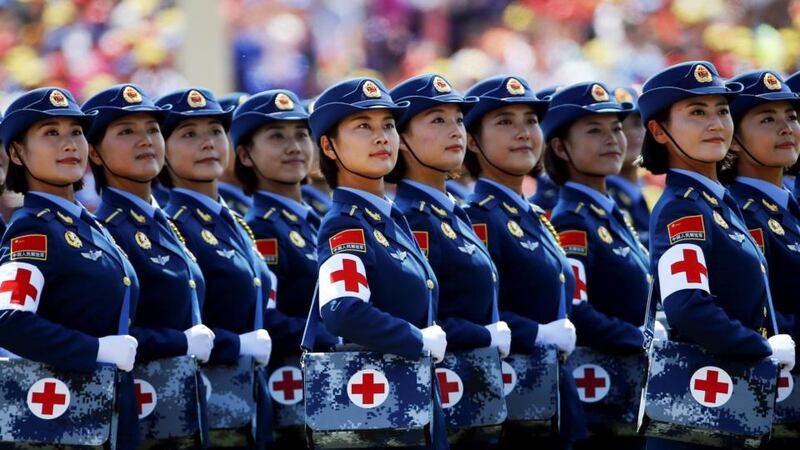 Military nurses look from atop a truck towards the Chinese president. Photograph: Damir Sagolj/Reuters