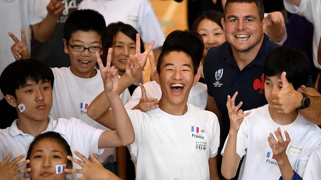 France’s hooker Guilhem Guirado (R) poses with children at Yamanashi Kenristu high school in Fujikawaguchiko, where the French squad will train. Photograph: Getty Images