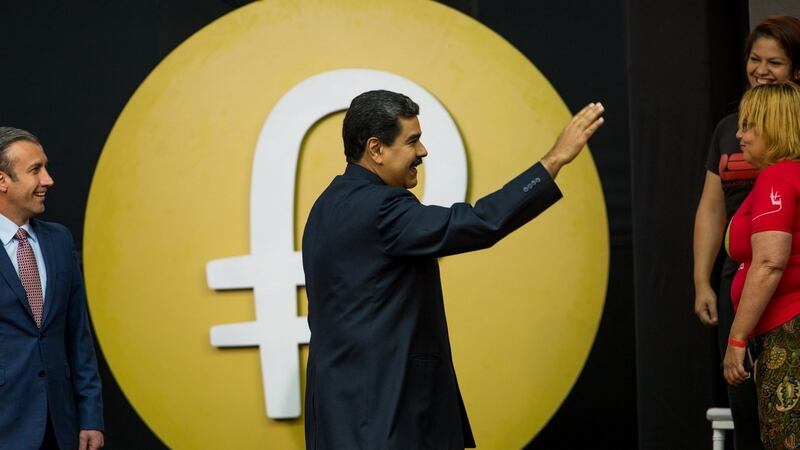 Venezuelan president Nicolas Maduro waves to the audience during a press conference regarding the new Venezuelan “petro” cryptocurrency, with the currency’s logo in the background, in Caracas, Venezuela. Photograph: Cristian Hernandez/EPA