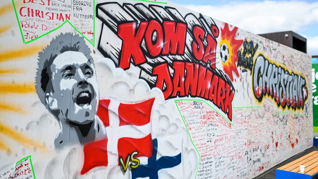 A picture shows a mural with the name and portrait of Denmark’s midfielder Christian Eriksen on a wall at the Football Village at Ofelia Beach in Copenhagen. Photo: Jonathan Nackstrand/AFP via Getty Images