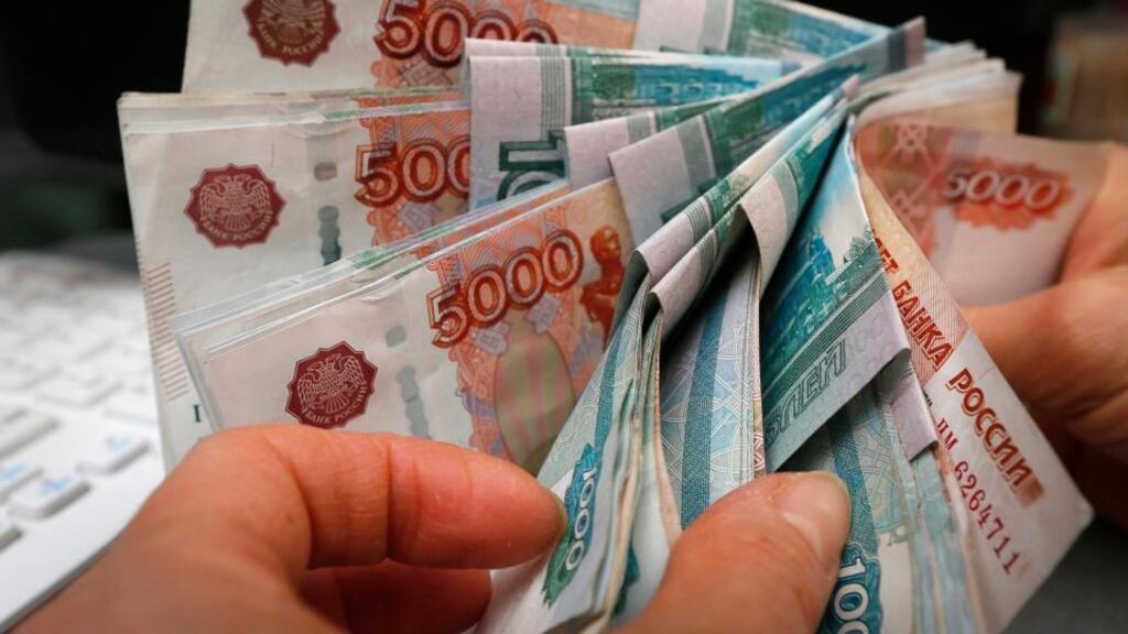 An employee counts Russian rouble banknotes at a small private shop selling home appliances in Krasnoyarsk. Photograph: Ilya Naymushin/Reuters