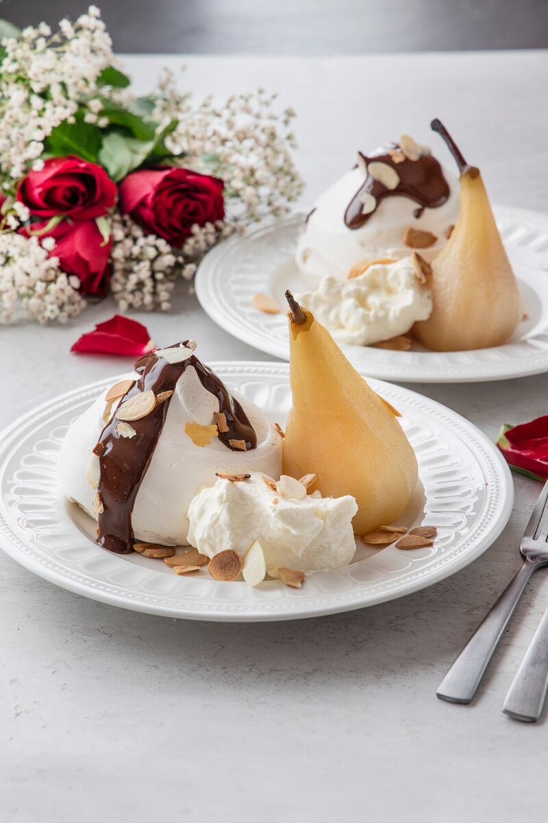 Meringues with poached pears and warm chocolate sauce. Photograph: Harry Weir