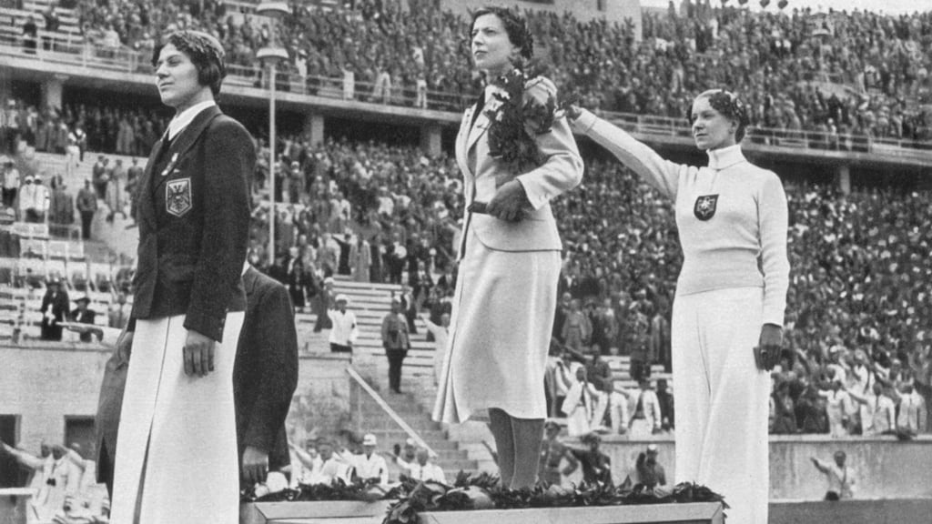 Helene Mayer of Germany raises her right arm in a Nazi salute after winning silver at the 1936 Berlin Olympics alongside Ellen Preis of Austria (bronze) and Hungary’s Ilona Elek-Schakerer (gold). Photo: Getty Images