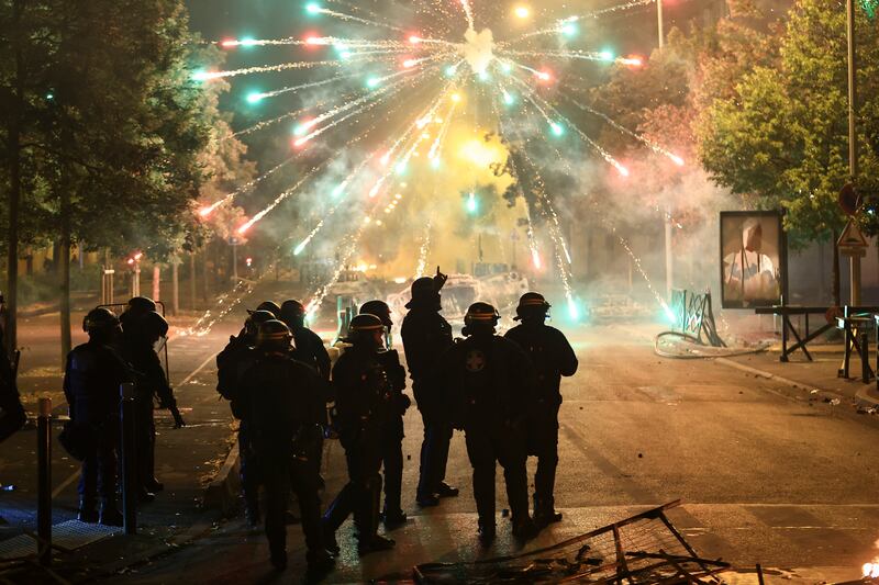 Police stand amid fireworks during the third night of protests in Nanterre. Photograph: Aurelien Morissard/AP