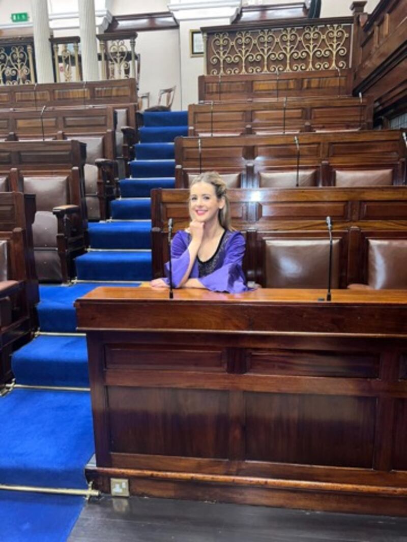 Caelainn McGrath sitting in her father’s seat in the Dáil chamber after she danced in Leinster House during Culture Night