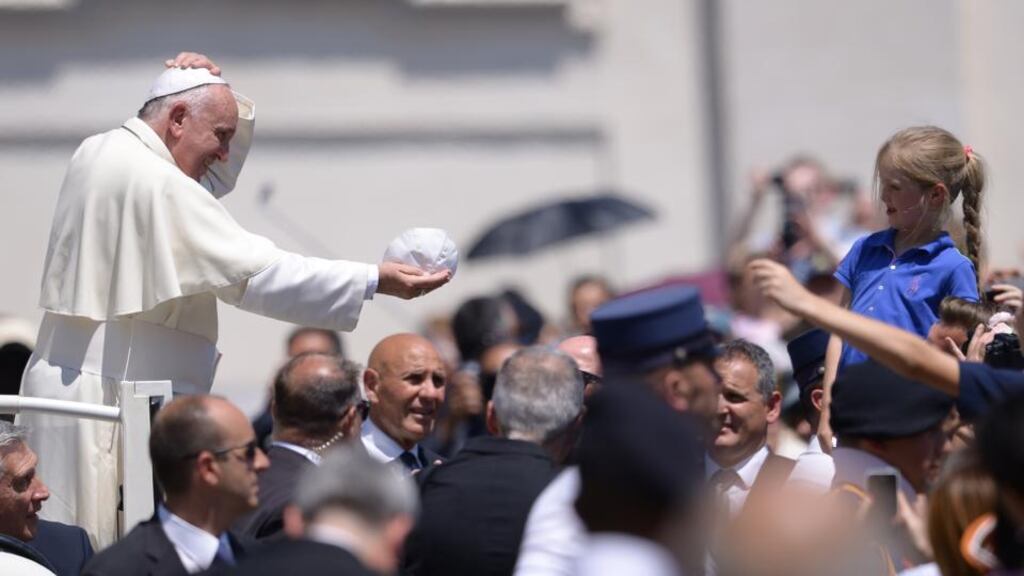 Pope Francis exchanges his skull cap with a little girl during his weekly general audience at St Peter’s Square in Rome on Wednesday. The pope has received a report recommending that bishops be made accountable for failures to protect victims of clerical child sex abuse. Photograph: Filippo Monteforte/AFP/Getty Images