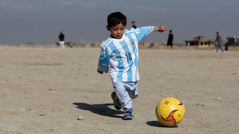Murtaza Ahmadi (5) wears a shirt signed by Barcelona star Lionel Messi as he plays football at the open area in Kabul in February this year. Photograph: Reuters