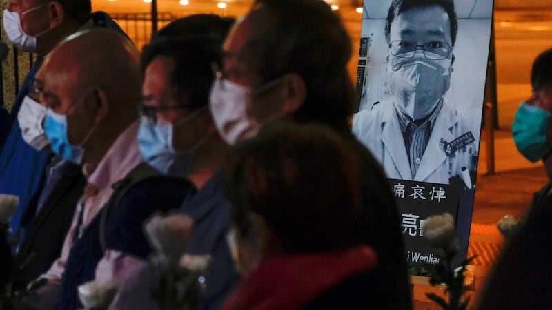 People attend a vigil for late Dr Li Wenliang in Wuhan. Photograph: Tyrone Siu/Reuters