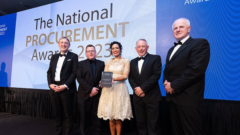 Robert Babington, awards judge, presents the best healthcare procurement project of the year award to Office of Government Procurement team