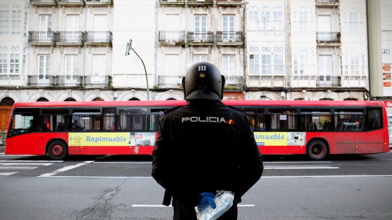 Policemen hand out face masks to commuters in A Coruna, Galicia, Spain on Monday. Photograph: Calabar/EPA.