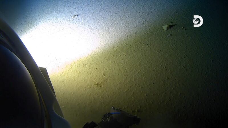 An object described by the Five Deeps Mariana expedition as ‘manmade’ is illuminated at top right of the image by the light of the submarine DSV Limiting Factor on the floor of the Pacific Ocean’s Mariana Trench. Photograph: Atlantic Productions for Discovery Channel via Reuters.