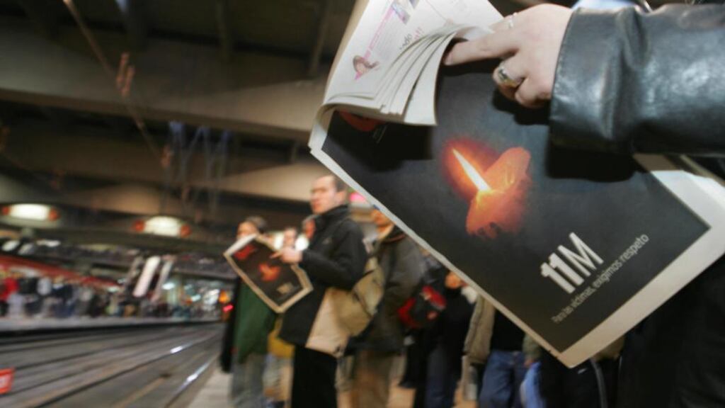 People waiting for a train on the platform 2 of Atocha railway station read newspapers on March 11th, 2005, with front pages commemorating the victims of the 2004 Madrid train bombing. Photograph:  Christophe Simon/AFP/Getty Images