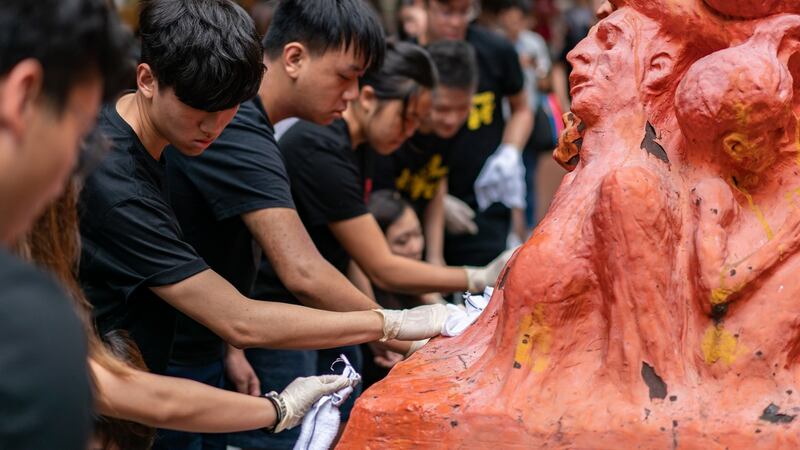 Students clean the “Pillar of Shame” statue, an art piece dedicated to the victims of the 1989 Beijing Tiananmen Square massacre, at the University of Hong Kong on Tuesday. Photograph: Anthony Kwan/Getty Images