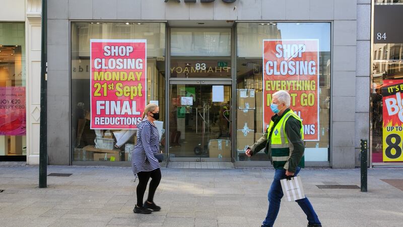People wearing face mask pass closed down stores on Grafton Street. Photograph: Gareth Chaney/Collins