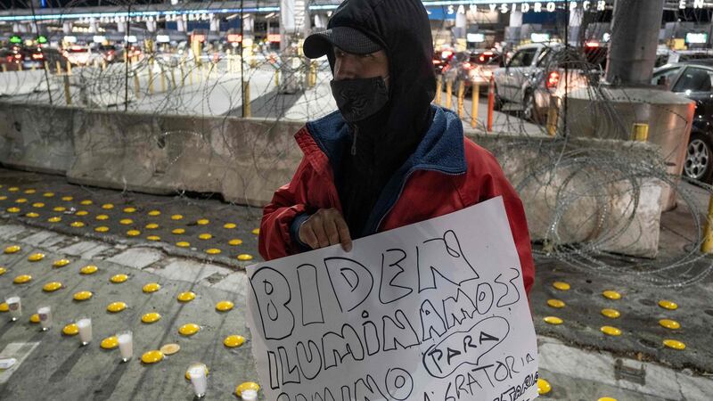 A migrant holds a sign reading “Biden: enlight the way for a humane immigration reform” at a vigil in Tijuana, Mexico, on Monday. Photograph: Guillermo Arias/AFP