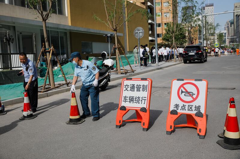 Police stand guard beside entrance of a school for China's college entrance exams, known as the gaokao. Photograph: EPA