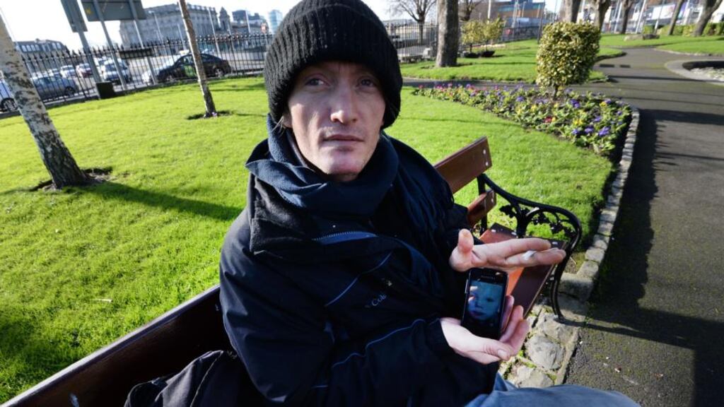 Tomas (43), from Slovakia, who has lived homeless in Dublin for the past four years, photographed in Wolfe Tone Quay park with a picture of his son. Photograph: Brenda Fitzsimons