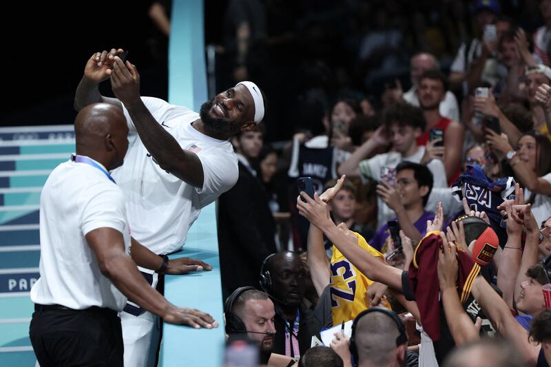 LeBron James takes selfie photos with a spectator's smartphone at the end of the men's preliminary round group C basketball match between Puerto Rico and USA during the Paris 2024 Olympic Games. Photograph: Thomas Coex/AFP via Getty Images