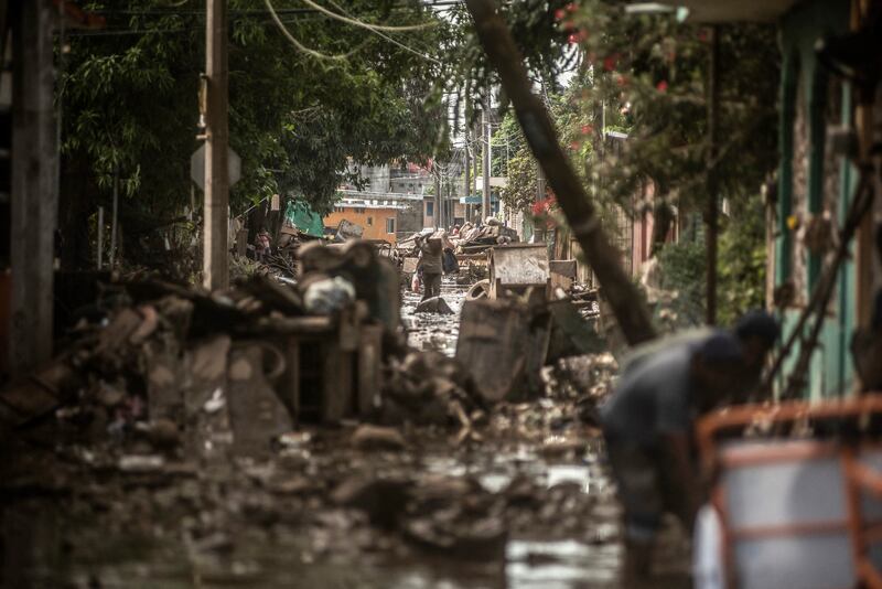 People wade through mud after severe flooding hit the town of Poza Rica, Veracruz state, Mexico, on Tuesday. Photograph: Hector Quintanar/AFP via Getty