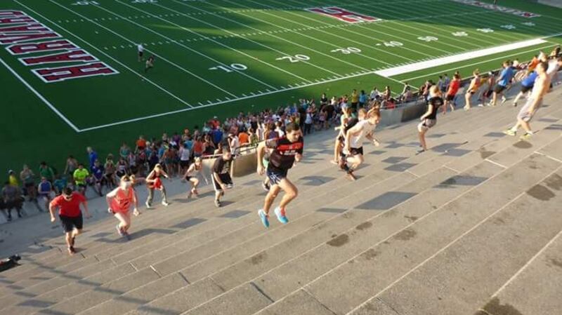 Dara Bree running up the steps of Harvard Stadium.