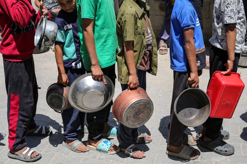 Palestinians gather to receive a hot meal at a food distribution point in the Nuseirat camp for refugees in the central Gaza Strip on Wednesday. Photograph: Eyad Baba/AFP via Getty Images