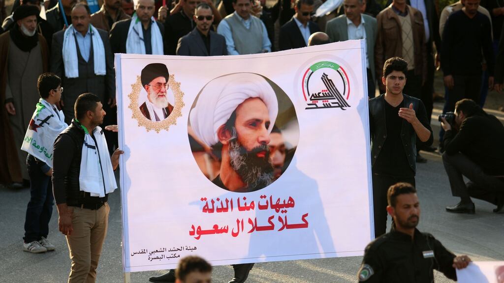 Shia Muslim Iraqis hold a banner bearing a portrait of prominent Shia cleric Nimr al-Nimr during a demonstration in Basra. Photograph: Haidar Mohammed Ali/AFP/Getty Images