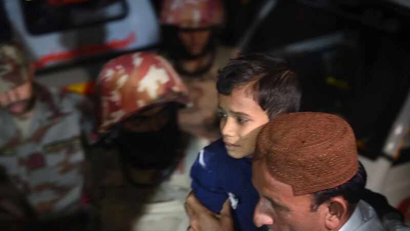 A man carries a boy injured after a bomb blast at a hospital in the Hub district, some 40km from Karachi. Dozens were killed when a bomb exploded at a remote Sufi shrine in southern Pakistan. Photograph: Asif Hassan/AFP/Getty Images