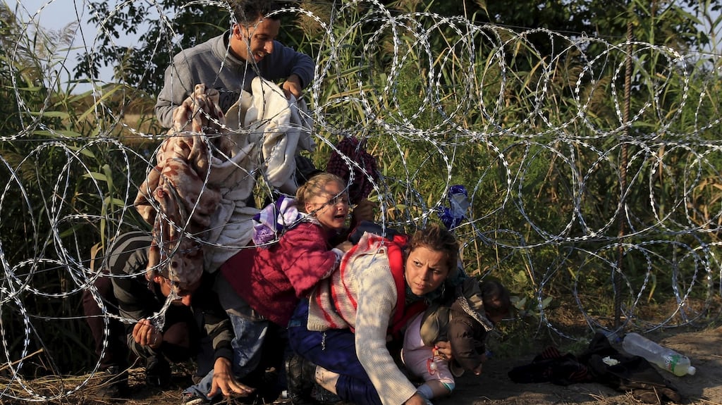 Syrian migrants cross under a fence as they enter Hungary at the border with Serbia last August. Photograph: Reuters