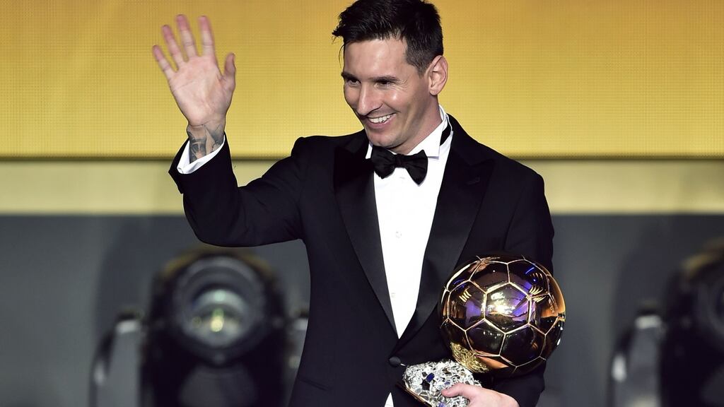 Lionel Messi waves holding his trophy after receiving the 2015 Fifa Ballon d’Or award  at the Kongresshaus in Zurich. Photograph: Fabrice Coffrini/AFP/Getty Images