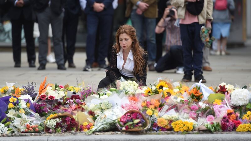 A woman kneels next to flowers left on the south side of London Bridge near Borough Market where Saturday night’s terror attack took place. Photograph: Reuters/Clodagh Kilcoyne
