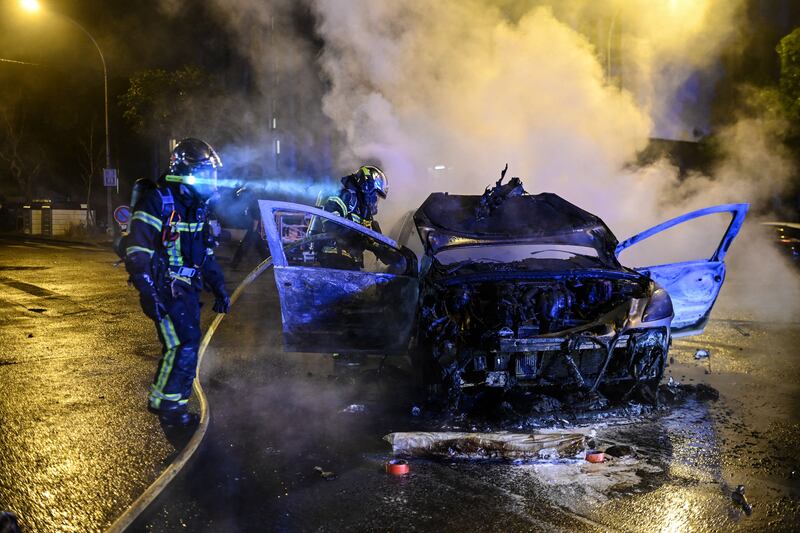 Firefighters extinguish a car that caught fire during riots in Nantes, western France on Saturday. Photograph: Sebastien Salom-Gomis /AFP via Getty Images