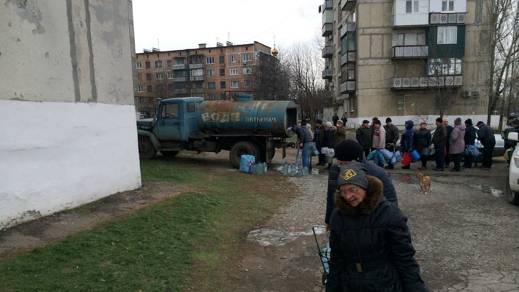 Valya Burakova and her neighbours collect water from a tanker in Toretsk, eastern Ukraine, where the water supply was cut by shelling on November 22nd. Photograph: Daniel McLaughlin