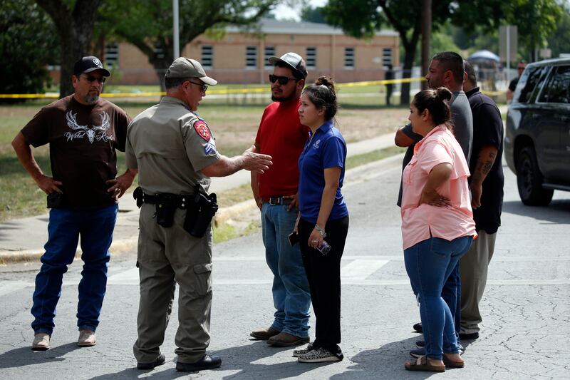A police officer talks to people asking for information outside the school in Uvalde, Texas. Photograph: Dario Lopez-Mills/AP