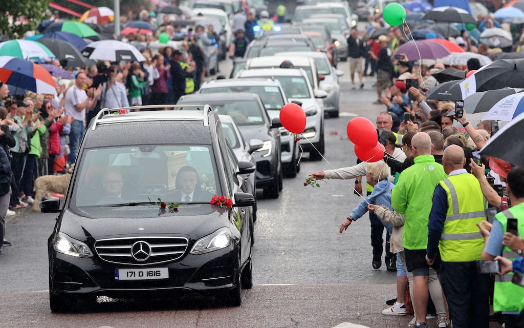 Fans throw roses on hearse of rock legend Christy Dignam. Photograph: Dara Mac Dónaill