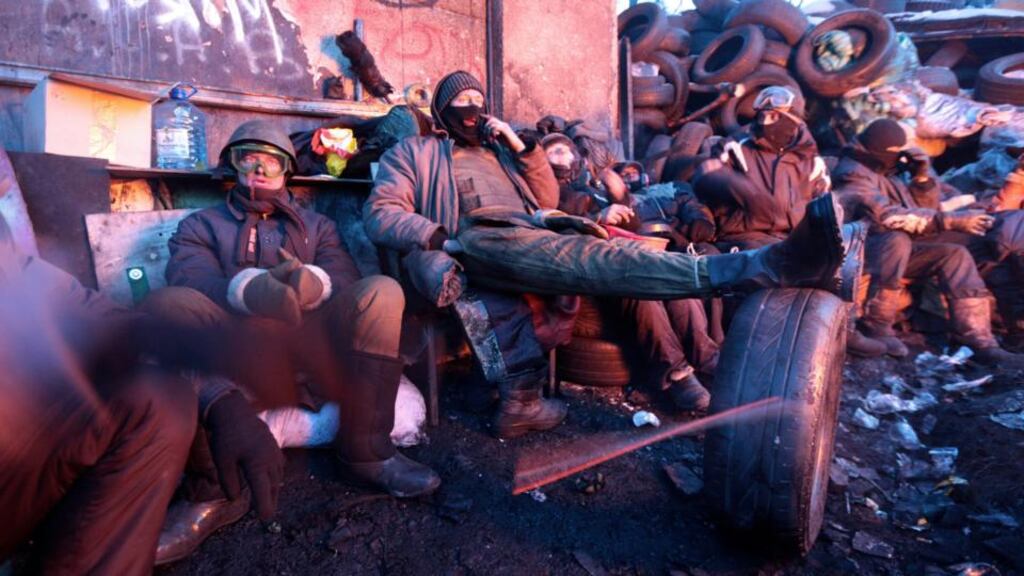 Anti-government protesters rest at a barricade at the site of clashes with riot police in Kiev on Wednesday. Photograph: Reuters