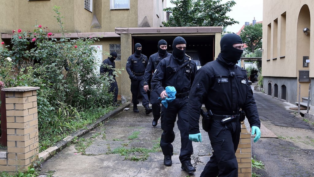 Masked police leave after searching a house in Hildesheim, Germany on Wednesday. Photograph: EPA