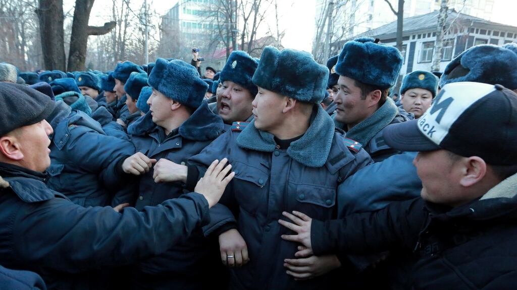 Kyrgyz police in front of protesters at a rally in support of Omurbek Tekebayev, the leader of the Ata Meken (Fatherland) party, in Bishkek, Kyrgyzstan. Photograph: Igor Kovalenko