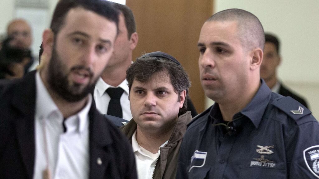 Yosef Haim Ben-David (centre) the third defendant for Killing Palestinian teenager Mohannud Abu Khdeir last year, is escorted by Israeli policemen at the district court in Jerusalem on November 30th, 2015. Photograph: Menahem Kahana/AFP/Getty Images
