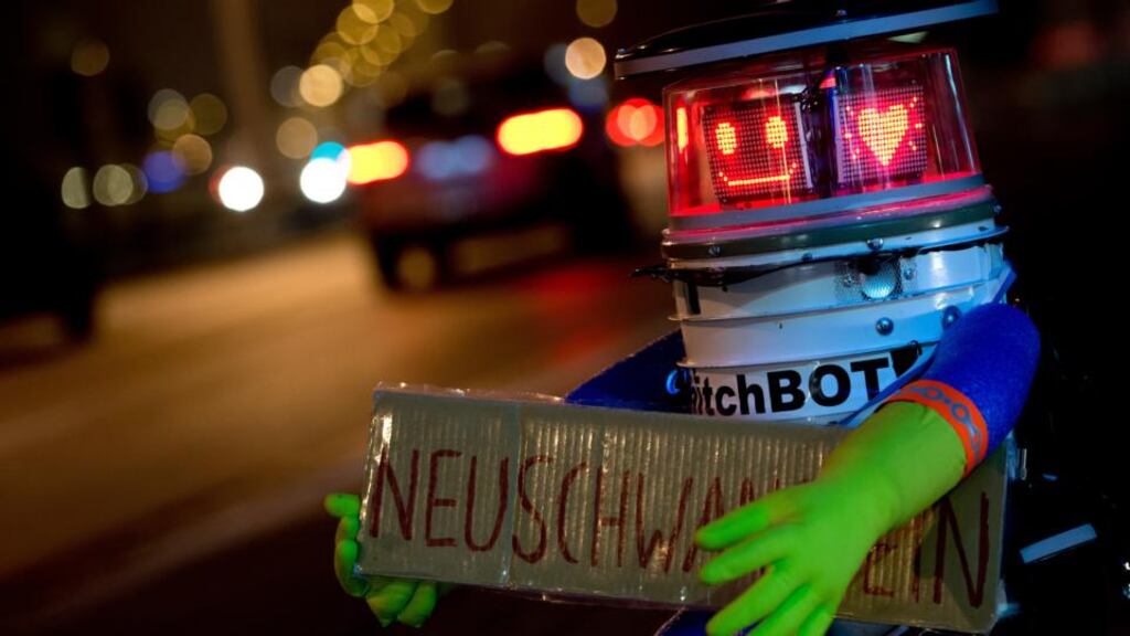hitchBOT holding a sign reading ‘Neuschwanstein’ as he waits for a lift at the roadside in Munich, Germany, on February 13th, 2015. Photograph: SVEN HOPPE/AFP/Getty Images