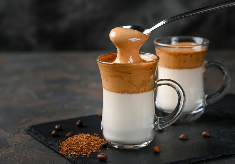 Two glass cups with Dalgona frothy coffee trend korean drink latte espresso with coffee foam on black background. Photograph: iStock