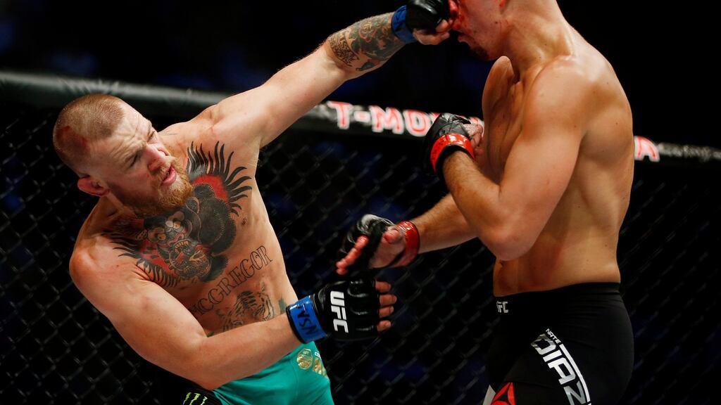 Conor McGregor punches Nate Diaz during their welterweight mixed martial arts bout at UFC 202. Photograph: Isaac Brekken/AP