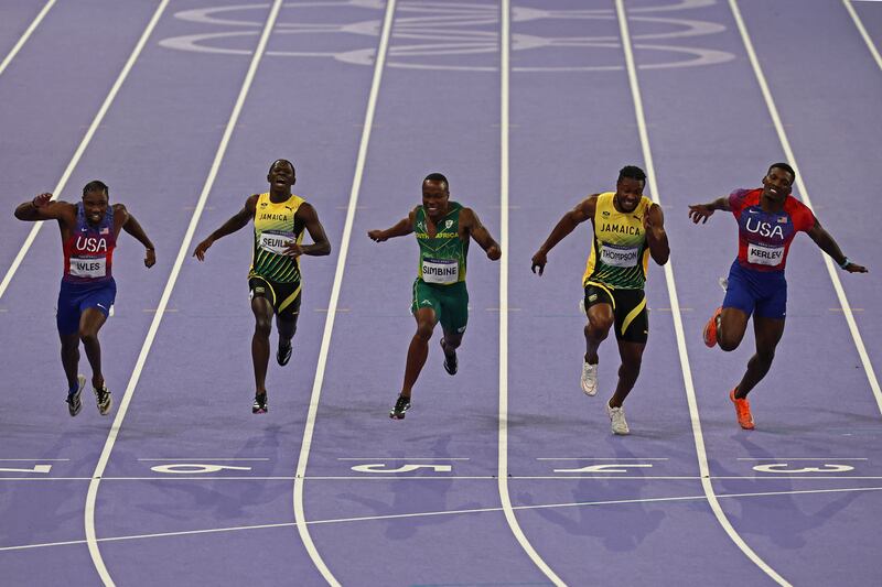 Noah Lyles (US, at left) crosses the finish line to win ahead of Oblique Seville (Jamaica), Akani Simbine (South Africa), Kishane Thompson (Jamaica) and Fred Kerley (US) in the men's 100m final at the Paris 2024 Olympic Games at Stade de France on Sunday. Photograph: Anne-Christine Poujoulat/AFP/Getty