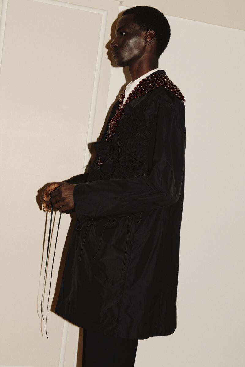 Black paper nylon jacket with rose detail €2,185, white cotton poplin shirt €660, black Venetian wool straight leg trousers 635, red crystal beaded scarf €1030