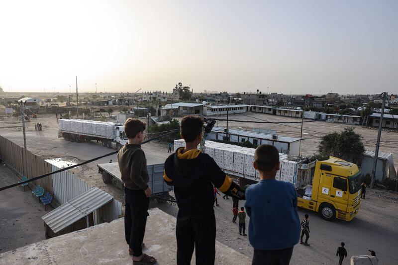 Young boys look at trucks carrying humanitarian aid entering the Gaza Strip via the Rafah crossing with Egypt. Photograph: Mohammed Abed/AFP via Getty Images