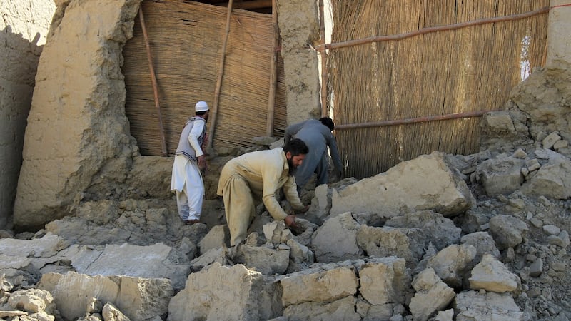 Afghan men clear bricks from a house. Photograph: Reuters/Parwiz