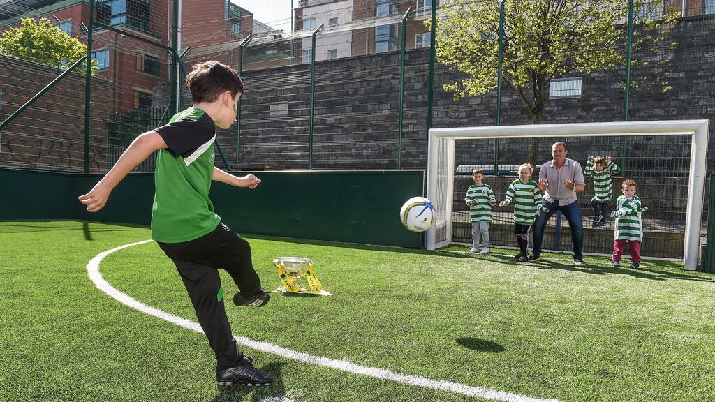 Seven-year-old Rhys Creane from Sheriff FC takes a penalty against Aviva’s FAI Junior Cup Ambassador, Richard Dunne, and some of the kids from the club during a visit to Sheriff Street in Dublin. Photo: Matt Browne/Sportsfile
