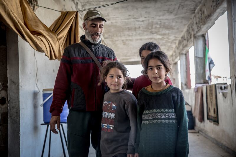 A single father and some of his nine children, who shelter in a destroyed school in Homs. Photograph: Sally Hayden