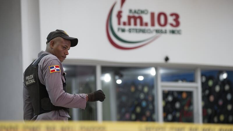 A Dominican policeman guards outside while investigations are going on at the facilities of the 103.5 radio station. Photograph: Orlando Barria/EPA