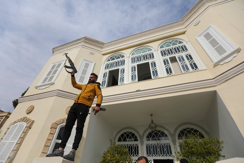 An anti-government fighter celebrates outside ousted President Bashar al-Assad's Al-Muhajirin residence in Damascus. Crowds ransacked his luxurious home after he fled for Russia. Photograph: Bakr al-Kassem/AFP